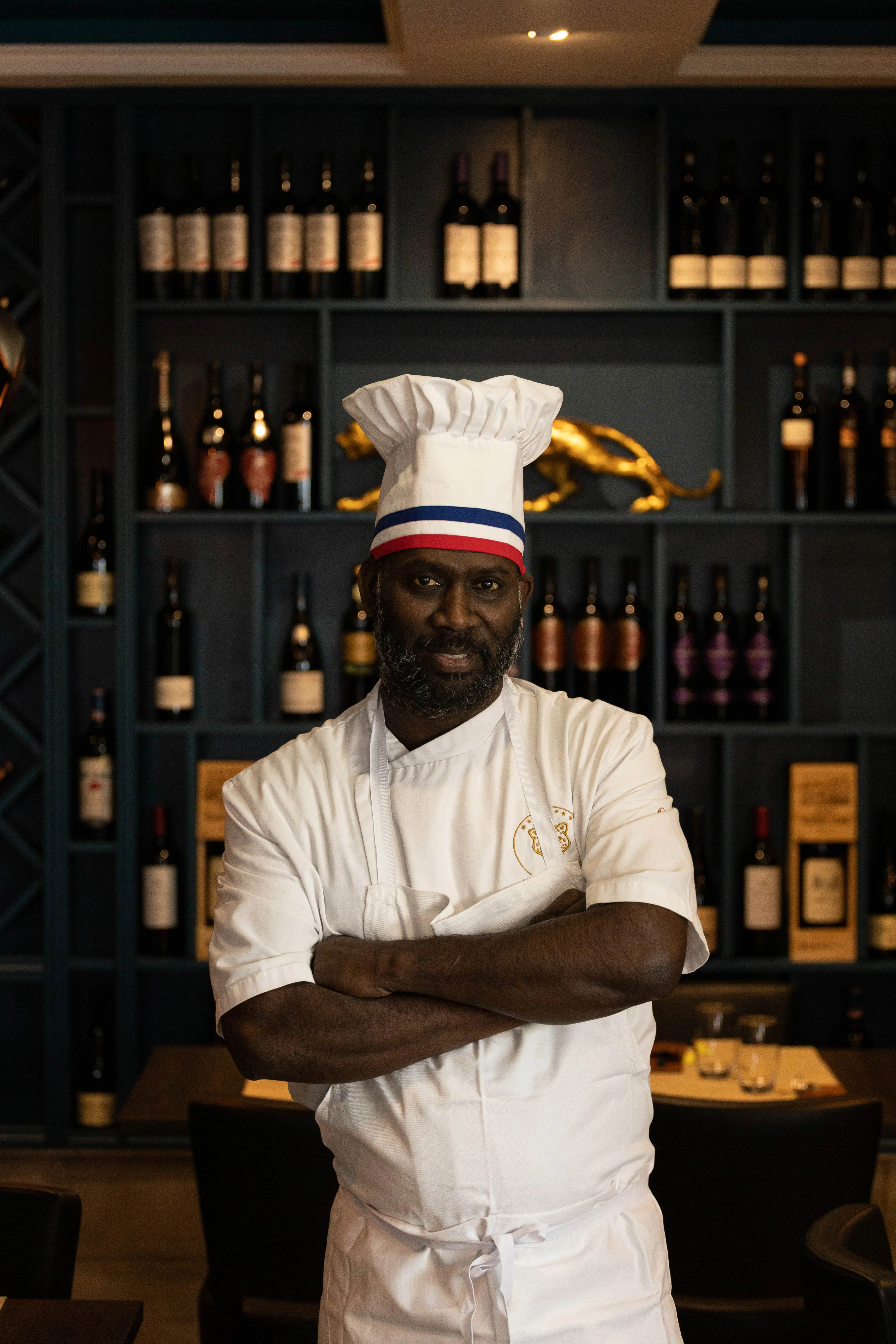 Mano, chef du Restaurant La Panthère, devant la cave à vins